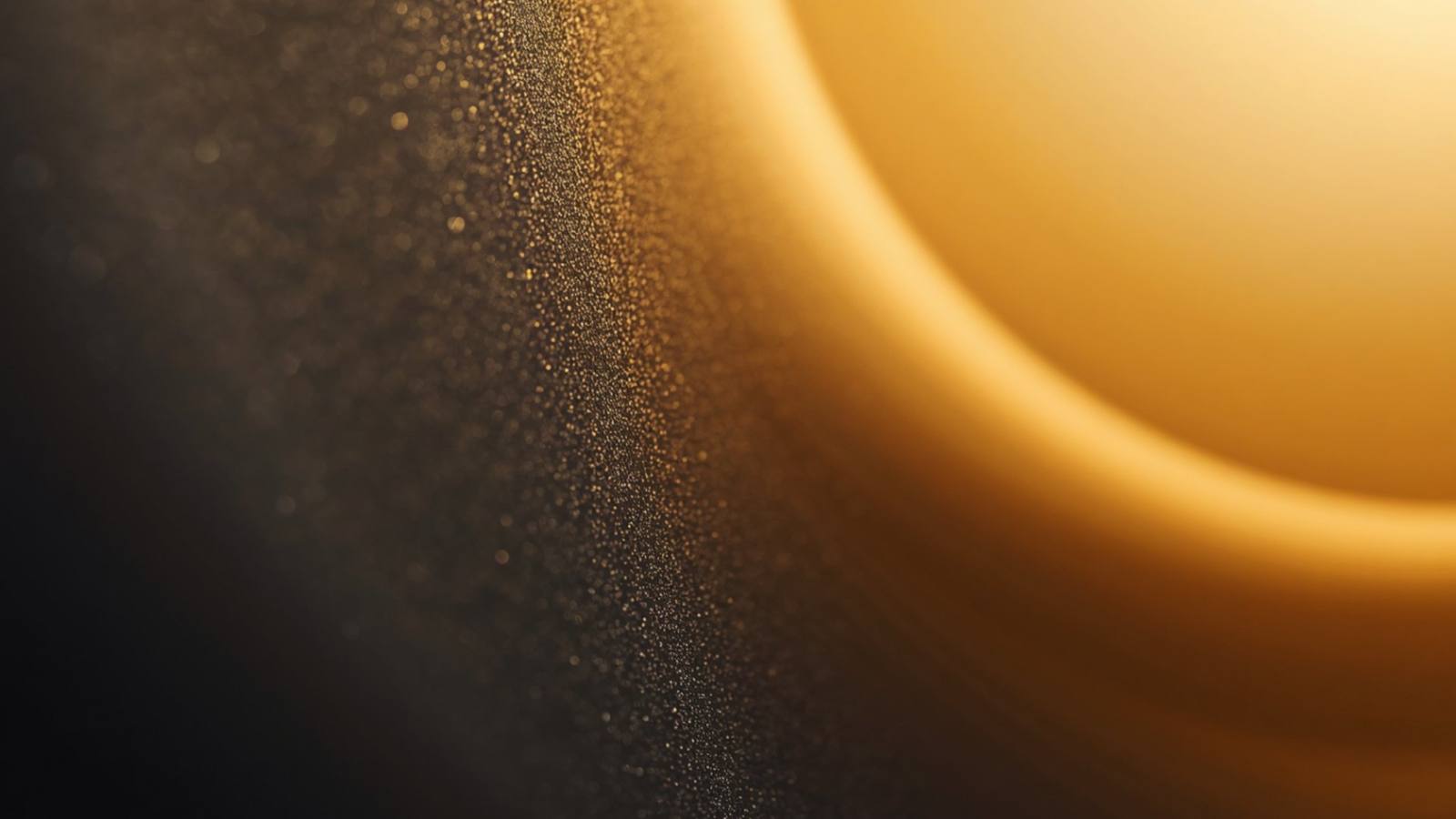 Abstract gold light and particles against a dark background.